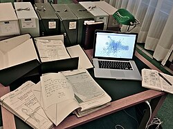 一部放置於一堆檔案材料附近的手提電腦