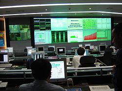 三個人在控制室內使用電腦工作
